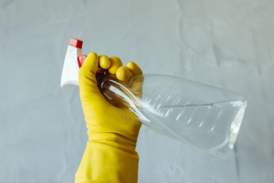 ゴム手袋をはめてスプレー洗剤を持つ様子
