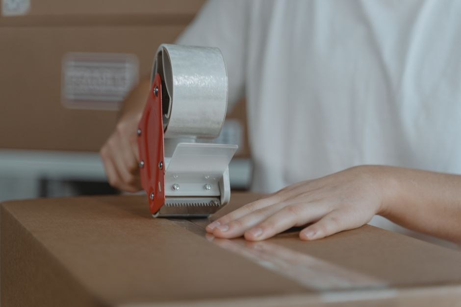 段ボールに荷物を梱包する手元
