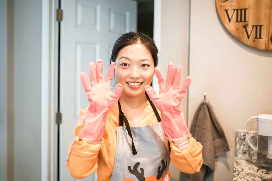 ゴム手袋とエプロンで掃除を始める女性